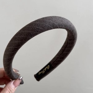 Détail du serre-tête en tissu gris avec étiquette de marque interne et texture croisée
