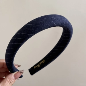 Détail d'un serre-tête en tissu rayé bleu marine avec rembourrage épais et doublure
