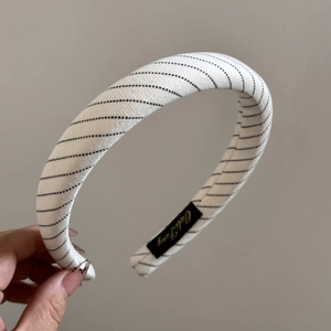 Détail d'un serre-tête large en tissu à rayures noires et blanches élégantes