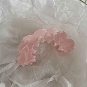 Close-up of pink and white marble pattern hair claw clip with wavy sawtooth design