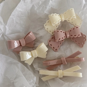 Detail view of 6-piece cream pink bow hair clips in lace and smooth resin finish