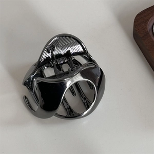 Λήψη macro του μεταλλικού κλιπ μαλλιών σε χρώμα gunmetal με γυαλισμένη υφή και ελατήριο