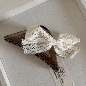 Detail of Korean style lace bow hair claw clip made of brown acrylic and white fabric