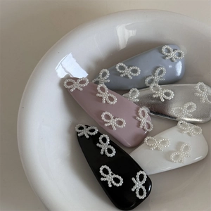 Cinque fermagli per capelli con fiocco di perle finte in colori pastello in una ciotola bianca