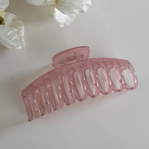 Détail de la grande pince à cheveux rose translucide avec ressort en métal et dents