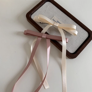 Detail of silk ribbon bow hair clips with elegant long streamers and metal spring clips