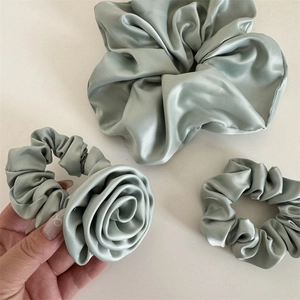 Lot de trois chouchous en satin vert sauge avec fleur de rose et bandeaux plissés