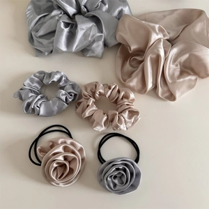 Detail of elegant French satin scrunchies and handmade rose hair ties in silk-like fabric