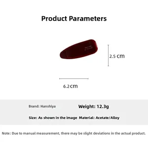 Détail de la barrette en acétate rouge foncé avec lettrage doré et dimensions de 6,2 cm