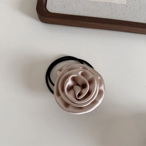 Detail view of champagne gold satin rose scrunchie with elegant vintage flower design