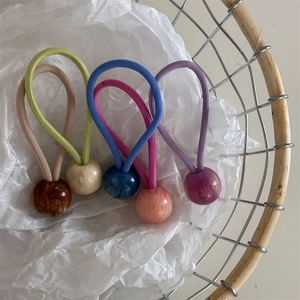 Cinq élastiques à cheveux de couleur bonbon avec perles en résine marbrée dans un panier