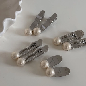 Ensemble de barrettes argentées avec perles blanches aux formes variées sur fond blanc