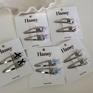Set of colorful heart bow hair clips in silver finish on display cards for women