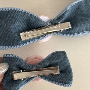 Rear view detail of denim fabric rose hair clips with pink plush lining and metal alligator clip