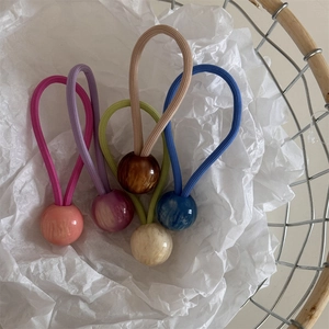 Lot de cinq élastiques à cheveux colorés avec perles marbrées dans un panier