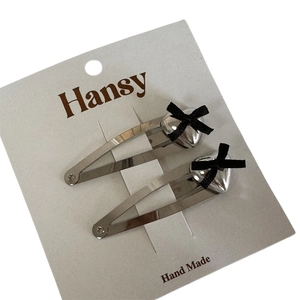 Silver alloy BB hair clips with 3D hearts and black bows on a display card
