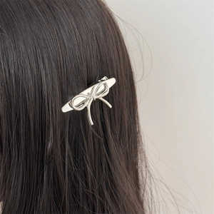 Barrette nœud en métal argenté élégante avec finition polie portée sur les cheveux
