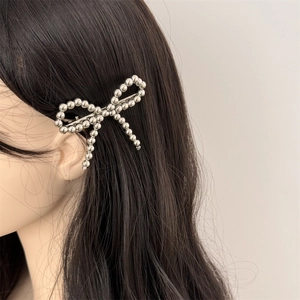 Elegant beaded bow hair clip in silver metal worn by model for daily styling