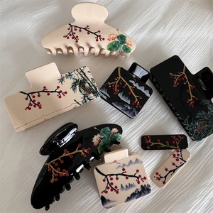 Detail of acetate hair claws featuring traditional Chinese plum blossom and bamboo patterns