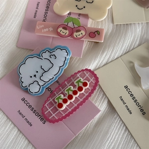 Set of cute cartoon dog hair clips in pink and blue colors on a decorative card