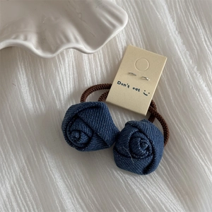 Detail of dark blue denim rose hair ties with elastic bands on decorative cards