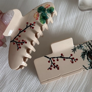 Detail of acetate shark hair clips featuring traditional plum blossom and lotus art