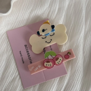 Detailed view of cute cartoon dog hair clip and pink rectangle clip with cherry design