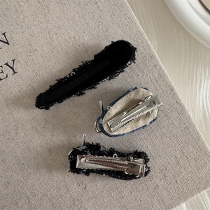 Detail view of denim fabric hair clips showing the durable metal alligator clip backing