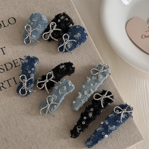 Macro view of blue denim hair clips with silver sequins and metallic bow details