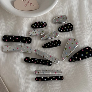 Detailed close-up of colorful polka dot pattern on assorted hair clip styles