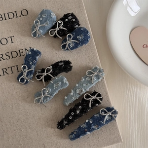 Detail view of denim and tweed hair clips with silver metallic bow and sequins