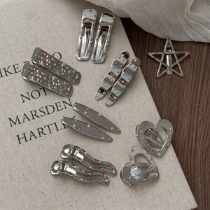 Close-up of colorful polka dot pattern on silver metal hair clips in various shapes