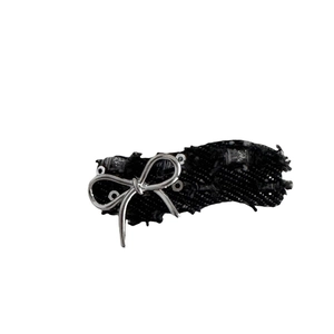 Denim bow hair clip with silver sequins and metallic trim on a black fabric base