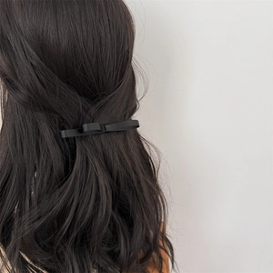 Élégante pince à cheveux nœud en soie noire double couche sur cheveux longs ondulés