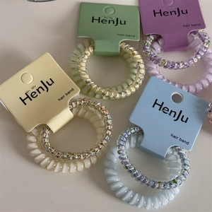 Pastel spiral hair bands set in cream, green and purple on branded display cards