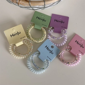 Detail view of colorful spiral telephone cord hair bands with floral patterns and card sets