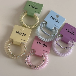 Close-up of colorful spiral telephone cord hair bands with floral patterns and pearl finish