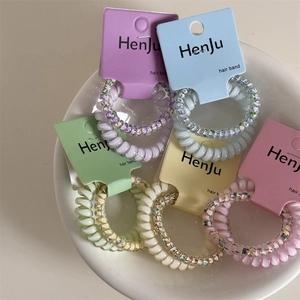 Close-up of spiral hair ties in pastel colors and floral patterns in a ceramic bowl