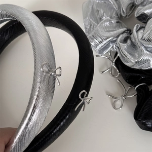 Gros plan détaillé du serre-tête en tissu argenté avec pendentif noeud élégant