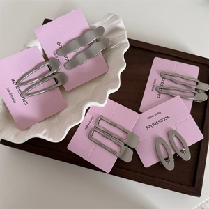Ensemble de barrettes à cheveux géométriques en métal argenté mat sur carte rose