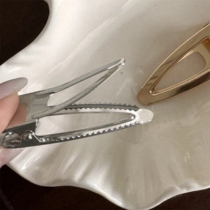 Close-up of metal hair clips with non-slip teeth and durable spring mechanism details