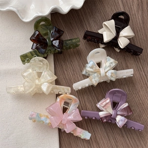 Flat lay of french acetate bow hair claws in various marble colors and patterns