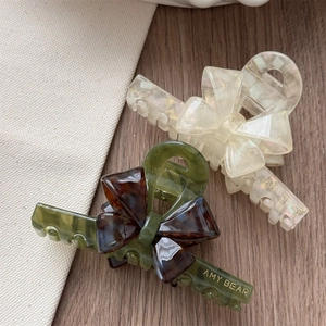 Detailed macro view of acetate bow hair claw clips with elegant marble pattern