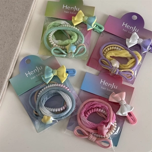 Detailed view of macaron colored hair tie sets and bow clips on display card