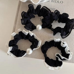 Set of four lace-edged scrunchies with faux pearl charms in elegant black and white