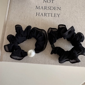 Detail of elegant black lace scrunchies with white pearl accent for ponytails