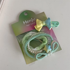 Close-up of mint green scrunchie set with star pendant and colorful hair accessories