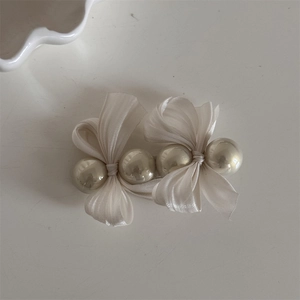 Detailansicht der eleganten cremefarbenen Satin-Haarschleife mit Kunstperlen