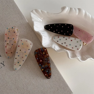 Détail de pinces à cheveux avec strass colorés sur motifs marbrés et écaille de tortue