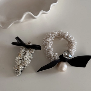 Detail of elegant black bow hair accessories with pearls and heart rhinestones